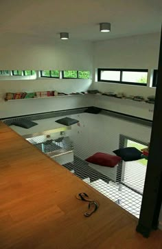 an indoor swimming pool in a house with wood floors and windows on the side wall