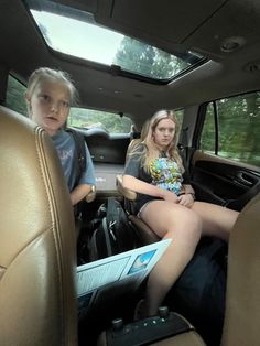 two children sitting in the back seat of a car