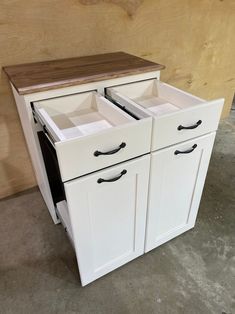 an unfinished kitchen cabinet with two drawers