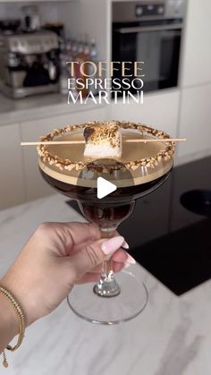 a person holding a wine glass with food in it and the words toffee espresso martini