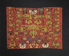 an old red and yellow rug with designs on it