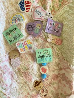 there are many badges on the bed sheet that say welcome home and new nurse to little kitty