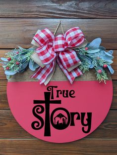 a pink door hanger with the words true story on it and a red bow