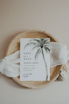 a palm tree save the date card on top of a wooden bowl with white yarn