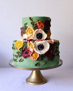 there is a green cake with flowers on it