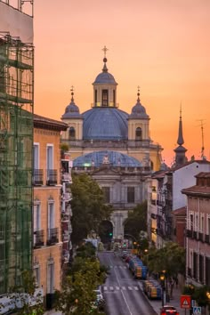 a city street with buildings and scaffolding on the sides at sunset or dawn