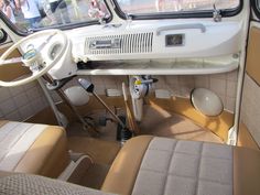 the interior of an old car with beige leather seats and steering wheel, along with other vehicles