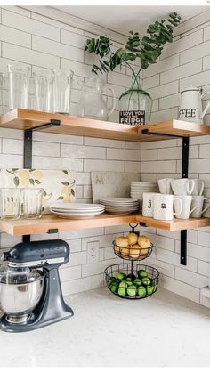 a kitchen counter topped with lots of plates and bowls next to a shelf filled with cups