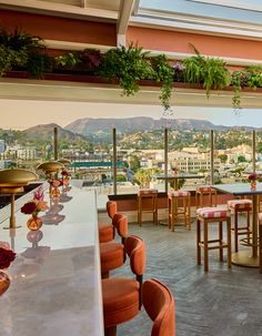 an outdoor dining area with tables, chairs and potted plants on the roof terrace