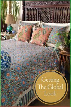 a bed with pillows and blankets on it in front of a wooden headboard that says getting the global look