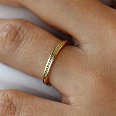 a woman's hand with a gold ring on it