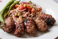 meatballs, beans and vegetables on a white plate