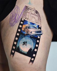 a woman's thigh with an image of a car on the film strip tattoo