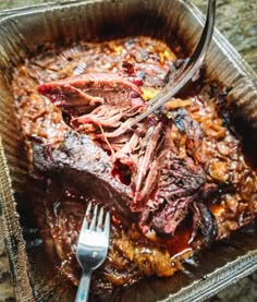 a piece of meat in a roasting pan with a fork