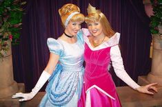 two women dressed as princesses posing for the camera