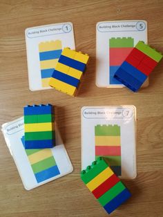 four pieces of lego building blocks sitting on top of a wooden table