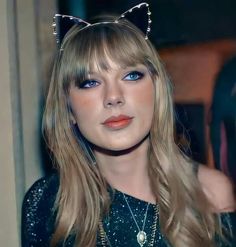 a woman with long blonde hair wearing a cat ears headband