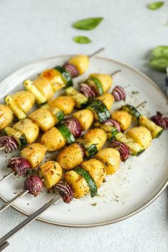 several skewers of food on a white plate