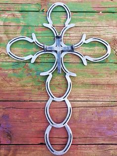 an ornate metal cross hanging on the side of a wooden wall