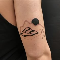 a woman's arm with a tattoo on it that has mountains and rocks in the background