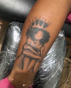 a woman's arm with a tattoo on it and a crown in the middle