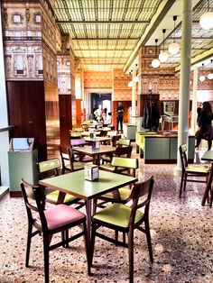 tables and chairs in a restaurant with people walking by