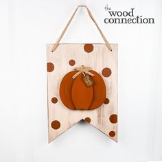 a wooden sign with two pumpkins hanging from it's side on a wall