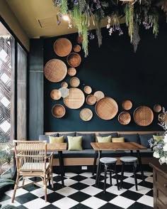 a black and white checkered floor with lots of wicker baskets hanging on the wall