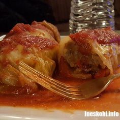 a plate with some food on it and a fork next to the plate that is covered in sauce