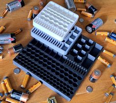 an assortment of batteries on a table with one battery in the middle and several empty ones around it