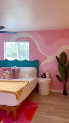 a bed room with a neatly made bed and pink walls