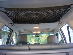 the interior of a vehicle with two seats and a net on the ceiling above it