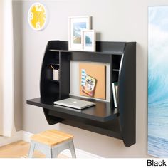 a computer desk with a shelf above it and pictures on the wall next to it