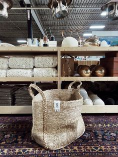 a large bag sitting on top of a rug next to a shelf filled with pots and pans