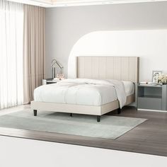 a white bed sitting in a bedroom next to a window