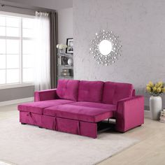 a living room with a fuchsia colored couch and white rug on the floor