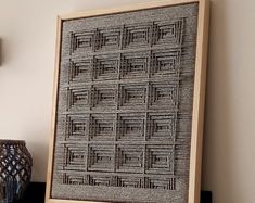 a wooden frame sitting on top of a shelf next to a vase