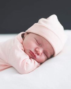 a sleeping baby wearing a pink hat