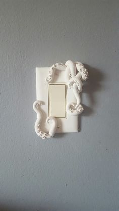 a white light switch sitting on the side of a wall next to a lamp fixture