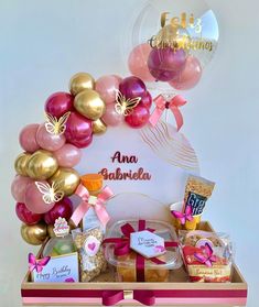 a pink and gold birthday hamper with balloons