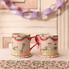 two coffee mugs sitting on top of a table