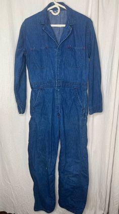 This jumpsuit is good used condition. There are some stains on the garment (pictured) and a few small holes. If you have any questions please feel free to ask. Flat Lay Measurements: Chest: 23 inches Shoulder: 18 inches Waist: 17 inches Hip: 20 inches Inseam: 29 inches Length: 59 inches Vintage Dark Wash Cotton Denim Jumpsuit, Vintage Cotton Denim Jumpsuit In Medium Wash, Vintage Denim Jumpsuit With Pockets, Vintage Denim Jumpsuit Overall With Pockets, Vintage Blue Shortalls, Vintage Medium Wash Washed Overalls, Vintage Washed Cotton Overalls, Vintage Medium Wash Overalls With Pockets, Vintage Medium Wash Overalls