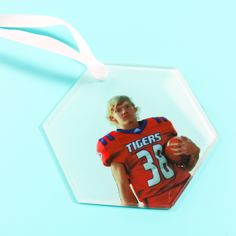 an ornament shaped like a football player holding a ball on a blue background