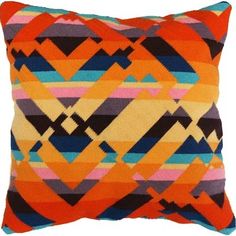 an orange and blue pillow with multicolored squares on it's back side