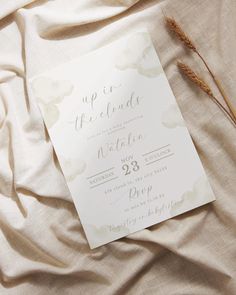 the wedding stationery is laid out on top of the bed sheets and linens