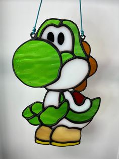 a green and white nintendo character ornament hanging from a string