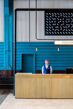 a man sitting at a desk in front of a blue building