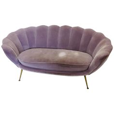 a purple couch sitting on top of a white floor next to a metal leg rest