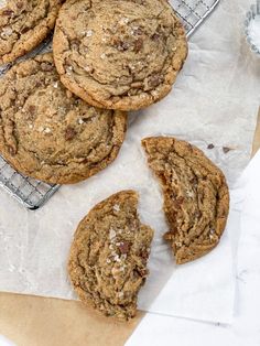 chocolate chip cookies on top of parchment paper next to a cooling rack with half eaten cookie