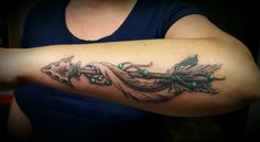 a woman with a feather tattoo on her arm